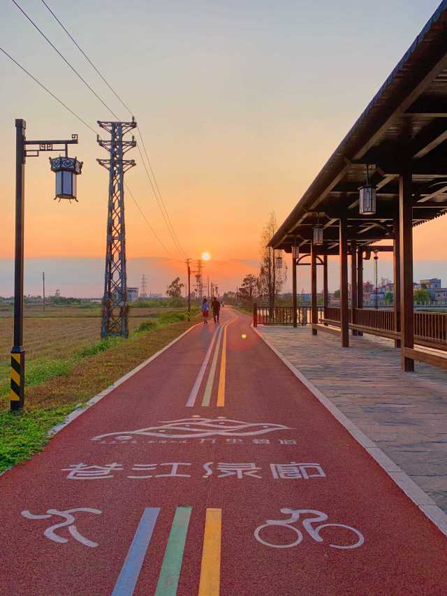 黃昏時分，人們迎著夕陽在蒼江綠廊漫步